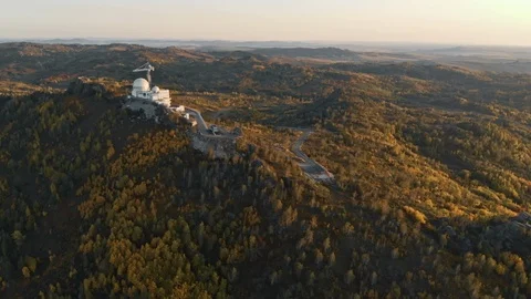 Mountain road leading to white building under construction with round roof Stock Footage 124113030