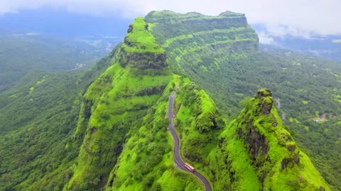 Mountain road passing through a vibrant green landscape video (Real Time). 스톡 동영상 282505822