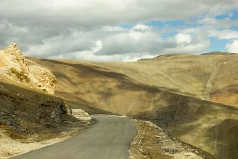 Mountain road with shadow from the clouds Stock Photos