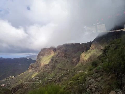 Mountain road through dramatic cloudy canyon landscape Stock Photos