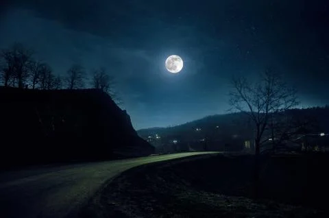 Mountain Road through the forest on a full moon night. Scenic night landscape Photos