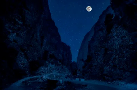 Mountain Road through the forest on a full moon night. Scenic night landscape Photos