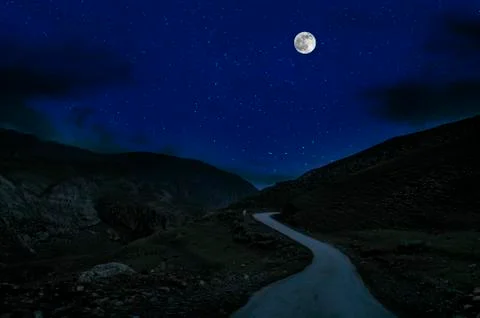 Mountain Road through the forest on a full moon night. Scenic night landscape Photos