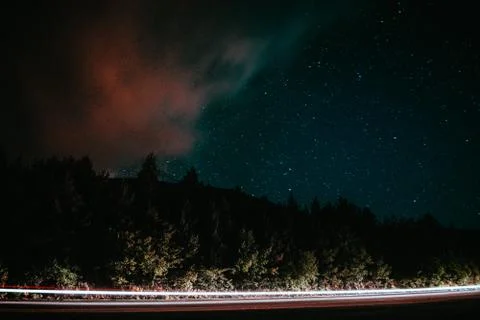 Mountain Road through the forest with a full stars sky at night. Stock Photos