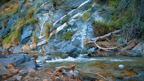 Mountain rocks with blue water falling down the river and broken branches. Slow  Stock Footage 105413022