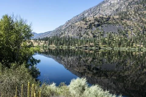 Mountain scene reflected on the pristine Blue Lake in Eastern Washington at the Stock Photos