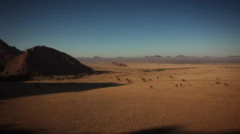 MOUNTAIN SHADOWS RECEDE FROM VAST GRASSLAND HD Stock Footage 45341908