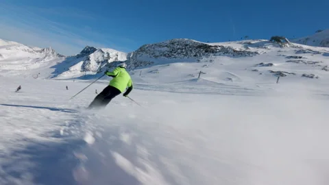 Mountain skier carve turns on a pristine snowy piste during a clear winter day Stock Footage 331256940