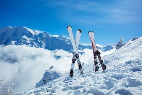 Mountain skis in snow over beautiful snowy alpine peaks Stock Photos