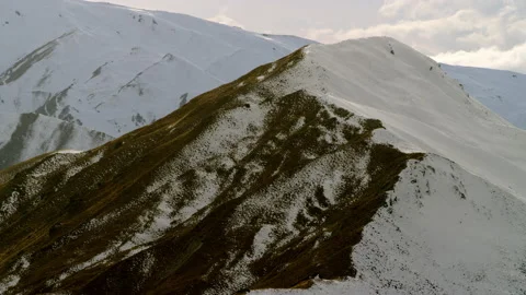 Mountain slope with snow on one side and tussock on the other Stock Footage 159695554