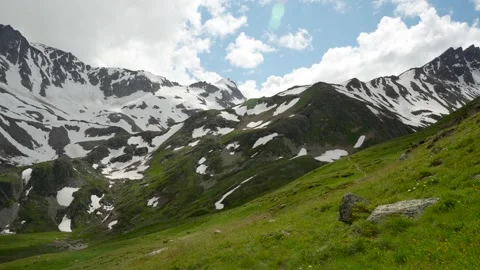 Mountain slopes contrast greenery and snow 库存影片 342713922