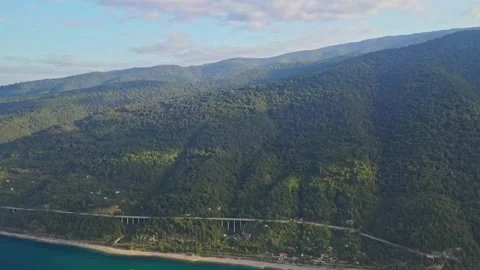 Mountain slopes covered with forest, highway, sea from above Stock Footage 151342494