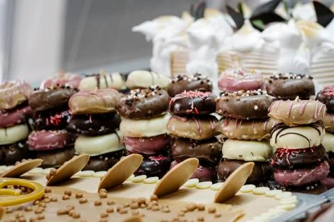 Mountain of small doughnuts decorated differently in an ice-cream display cas Stock Photos