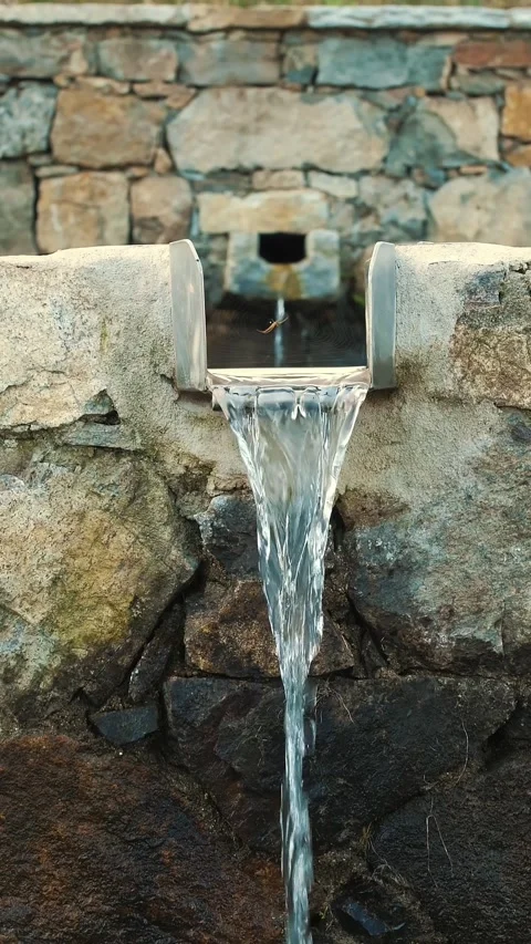 A mountain spring. Drinking water for animals. A stone waterfall. A trough Stock Footage 314432836