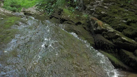 Mountain spring streams in slow motion flow along rocky slopes of the mountains Stock Footage 228491291