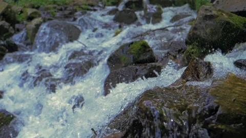 Mountain spring streams in slow motion flow along rocky slopes of the mountains Video stock 228491838