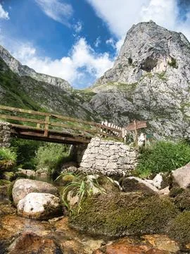 Mountain stream and rustic Picos de Europa bridge - Low-angle view of a cle.. Stock Photos