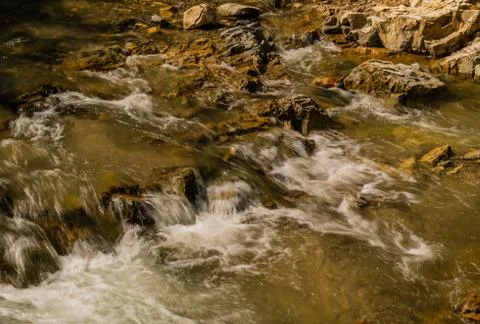 Mountain stream cascading over rocks and boulders Stock Photos