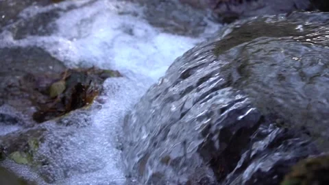 Mountain stream with crystal clear drinking water flows down the stones Stock Footage 144702325