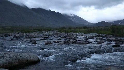 Mountain stream in the evening illumination against the background of mountains Vidéo 93954071