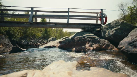 Mountain Stream Flowing Beneath Rustic Wooden Footbridge Stock Footage 341032821