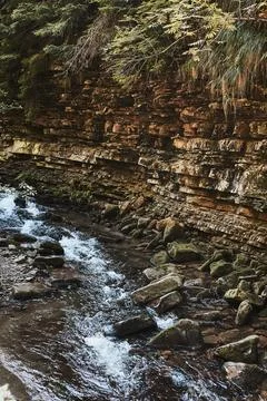 Mountain stream flowing down at rocky wall. Mountain landscape. Natural scene Stock Photos