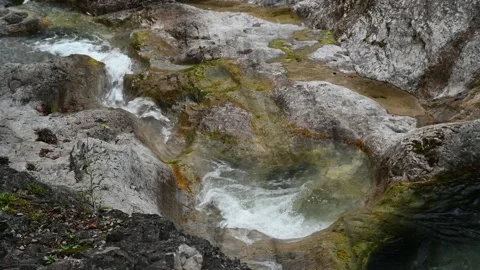 A mountain stream is flowing over rocks and through a pool Stock-Footage 211468348