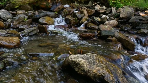 Mountain stream flowing over rocks in natural setting Stock Footage 345385746