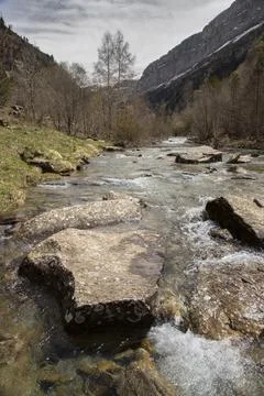 Mountain stream flowing over rocks in pyrenees valley Stock Photos