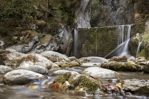 Mountain stream flowing over rocks with small waterfall Stock Photos