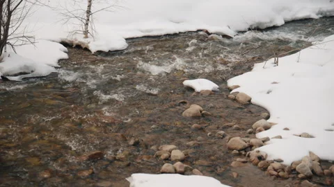 Mountain stream flowing through snowy winter landscape Stock Footage 331799743