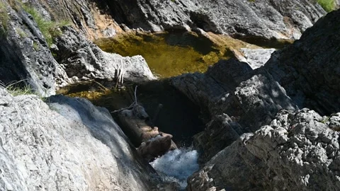 A mountain stream flows between rocks and through pools Stock-Footage 219645644