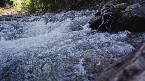 Mountain stream flows, crashes, and bubbles along Stock Footage 127119029