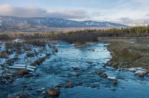 A mountain stream flows at the foot of the Zigalga Range Stock Photos