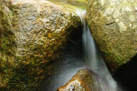 A mountain stream flows over rocks into a lake. Picturesque river mountains of Stock Photos