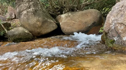 A mountain stream flows through large stones, foam from the flow of water Stock Footage 125315953