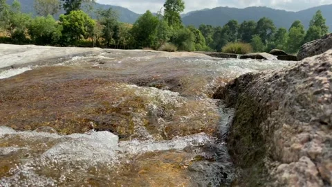 A mountain stream flows through large stones, foam from the flow of water Stock Footage 125324578