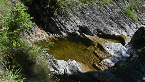 A mountain stream flows through pools between rocks 스톡 동영상 219645706