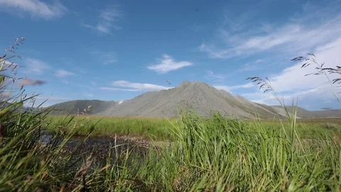 A mountain stream flows through the valley against the backdrop of the mountains Видео 93954300