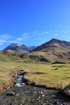 Mountain stream in front of mountains Stock Photos