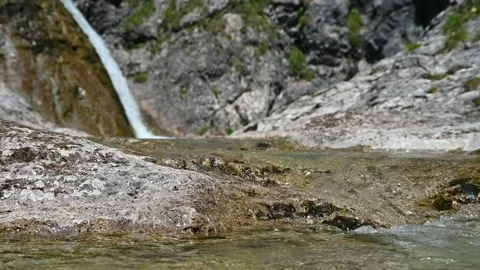 A mountain stream in front of a waterfall with rocks (slow motion) Stock Footage 219636650