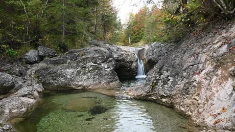A mountain stream with a pond and a waterfall in autumn 스톡 동영상 260864554