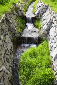 Mountain stream running through a forest Stock Photos