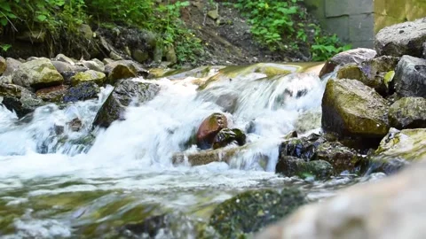 A mountain stream with a stone threshold and sunlight Stock Footage 199657085