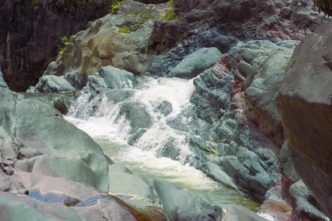 Mountain stream with a strong current among the rocks in the tropics Stock Photos