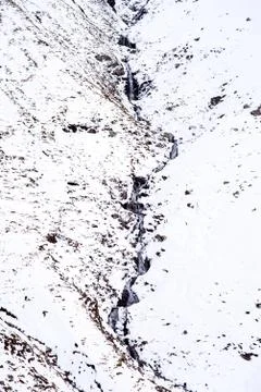 Mountain stream through snow Foto stock