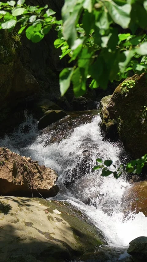 Mountain stream water flowing over rocks Stockbeeldmateriaal 346775944