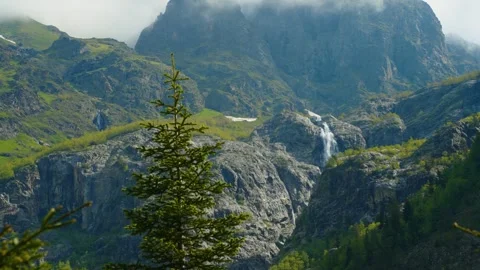 A mountain stream waterfall shrouded in clouds and mist Stock Footage 314632293
