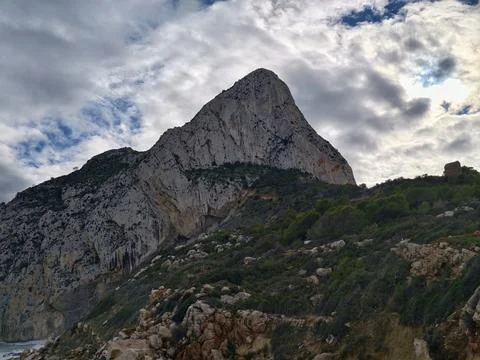 Mountain summit amid storm clouds, Foreboding mountain crest surrounded by Stock Photos