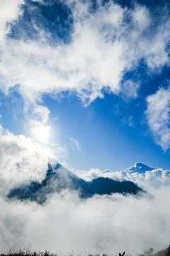 Mountain summit covered by sea of cloud with blue sky in the morning 写真素材